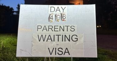 A sign on the lawn of Alireza Azizi denotes how long it's been since his parents' temporary resident visa application was submitted to Immigration, Refugees and Citizenship Canada. As of Friday, the tally is now 500.