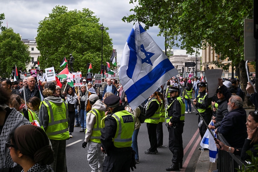 حشود من المتظاهرين المؤيدين لفلسطين وتوحيد المملكة ضد المتظاهرين المقسمين بواسطة الشرطة.